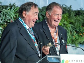 Peter Mahovlich offers his brother Frank a hundred dollar bill for saying nice things about him onstage at the 18th annual Sports Celebrity Breakfast, raising funds for the Cummings Jewish Centre for Seniors in Montreal Sunday June 12, 2022. The Mahovlichs were Stanley Cup champions on the Montreal Canadiens of the 1970s.