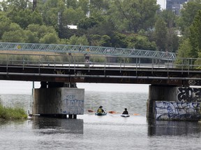 People leisurely paddle a kayak along the Lachine Canal in Montreal, on Wednesday, June 15, 2022.