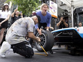 Canadian singer Karl Wolf and Olympic gold medalist hockey player Laura Stacey win their heat in the tire-changing competition on Crescent St. on Thursday.