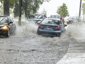 Cars splash through flooded St-Joseph Blvd. in Lachine during a thunderstorm June 16, 2022.