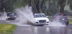 Cars splash through flooded St-Joseph Blvd. in Lachine during a thunderstorm June 16, 2022.