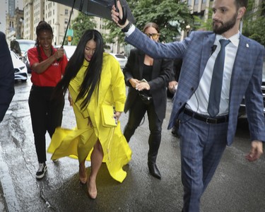 Pianist and composer Chloe Flower (in yellow) who was to perform at the Grand Prix Party at the Ritz-Carlton Hotel, arrives at the event.