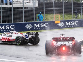 Team Mercedes' George Russell cuts the corner to avoid the car of Team Haas F1's Kevin Magnussen during a wet qualifying round at the Formula One Canadian Grand Prix at Circuit Gilles-Villeneuve on Ile Notre-Dame in Montreal on Saturday June 18, 2022.