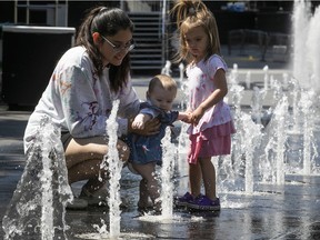 Seven-month-old Harper Adams enjoys her first visit to the fountain with her two-year-old sister Isla and their mother, Ocanne Lapointe, at the Place des Festivals on June 20, 2022.