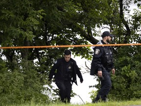 Montreal police officers leave the area near where Adalya Dorvil, who was reported missing earlier on Tuesday, was found on the shore of the St. Lawrence River, in Montreal, on Tuesday, June 21, 2022.