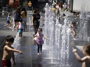 Alessandra Edson joins other kids in cooling off in the fountain of Place des Spectacles in Montreal, on June 24, 2022.