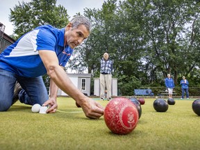 Greg Nurse uses a tape measure to determine a scoring bowl at the Pierrefonds Lawn Bowling Club on June 22.