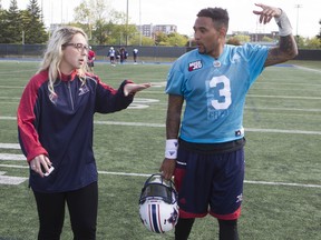 Catherine Raîche, who is the Montreal Alouettes' co-ordinator of football administration, speaks with quarterback Vernon Adams Jr. following Alouettes practice on Sept. 28, 2016.