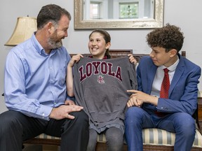 Mark Noble's daughter Emily tries on her brother Noah's old Loyola High School sweatshirt at their home in Montreal. The men in the Noble family have been attending Loyola for four generations. Emily will be the first girl in the family to attend in 2024.