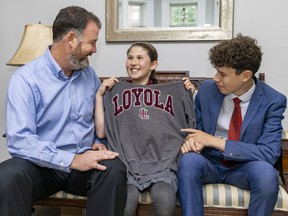 Mark Noble's daughter Emily tries on her brother Noah's old Loyola High School sweatshirt at their home in Montreal.  The men in the Noble family have been attending Loyola for four generations. Emily will be the first girl in the family to attend in 2024.