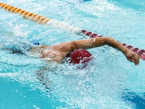 Young athletic man swimming in olympic pool.