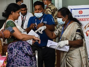Health workers screen passengers arriving from abroad for Monkeypox symptoms at Anna International Airport terminal in Chennai, India, on June 3, 2022.