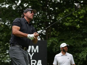 Dustin Johnson looks on as Phil Mickelson plays from the 4th tee on the first day of the LIV Golf Invitational Series event at the Centurion Club in St Albans, north of London, on June 9, 2022. The LIV Golf Invitational London, the launch event of a lucrative and divisive series that is rocking the sport is a US$25-million event, the biggest purse in history.