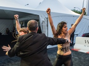 Topless protesters crash a Grand Prix event in Montreal in 2014. The body writing reads: Sex Slavery.