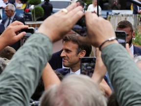 French President Emmanuel Macron greets supporters as he arrives to vote in the second round of French parliamentary elections, at a polling station in Le Touquet-Paris-Plage, France, June 19, 2022.