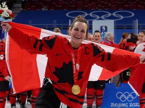 Marie-Philip Poulin celebrates with her gold medal during the medal ceremony in Beijing.