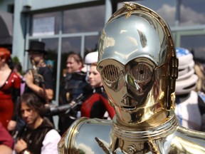 Star Wars character C-3PO and other participants pose during a press conference ahead of Montreal Comiccon in 2012.