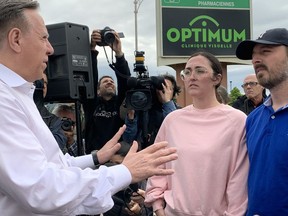 Quebec Premier François Legault speaks with Charles-David Bergeron-Brisson and his partner Erika Simard, who had to leave their home along with their children due to landslides in La Baie, a borough of Saguenay, on Wednesday, June 22, 2022.