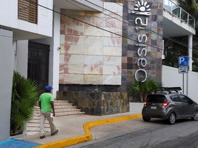 A man walks by Oasis 12 condo where two Canadian citizens, a man and a woman, were killed by unknown assailants, authorities said on Tuesday, in Playa del Carmen, Mexico, June 21, 2022.