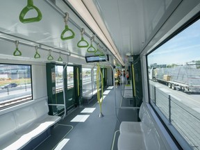 A train rolls along the track in between lanes of an freeway during a media tour of the the Reseau express metropolitain (REM) in Brossard, Que. on Thursday, June 10, 2021. The automated light train network will have 26 stations and 67 km of tracks across Greater Montreal.