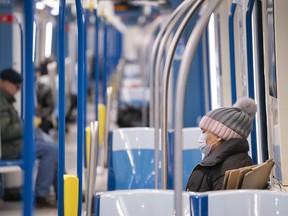 A commuter wearing a protective mask rides a near empty subway train in Montreal, on Wednesday, April 22, 2020. Masks will no longer be required on public transit in Quebec beginning today.
