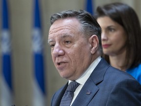 Quebec Premier Francois Legault looks up as he appraises the ending session at a news conference, Friday, June 10, 2022 at the legislature in Quebec City. Legault is flanked by Quebec Deputy premier and Public Security Minister Genevieve Guilbault, right, looks on. Quebecers will go to the polls for a general election on Oct. 3 of this year.