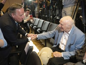 Quebec Premier François Legault, left, greets iconic Quebec singer and poet Gilles Vigneault before a funding announcement for a new music hall Thursday, June 23, 2022, in Montreal.