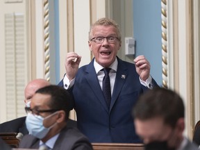Quebec Labour, Employment and Social Solidarity Minister Jean Boulet responds to the Opposition during question period at the Legislature in Quebec City, Thursday, May 12, 2022. Quebec Premier Francois Legault, left, looks on.