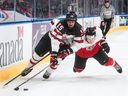 Canada's Shane Wright (15) and Austria's Tobias Sablattnig (12) battle for the puck in action at the IIHF World Junior Hockey Championships in Edmonton on December 28, 2021. The consensus pick for the top pick in the This year's NHL draft pick is Wright of the Kingston Frontenacs, writes Jack Todd. 