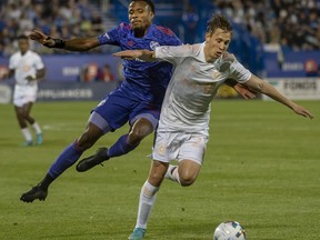 FC Cincinnati defender Alvas Powell, left, and CF Montreal midfielder Lassi Lappalainen battle during second half MLS action in Montreal on Saturday, May 28, 2022. CF Montréal is looking to keep its strong run of form going as it returns from Major League Soccer's two week international break with a match Saturday against Austin FC.