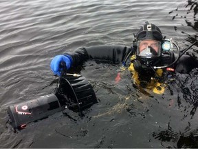 A closeup of a diver wearing blue gloves and holding search equipment.