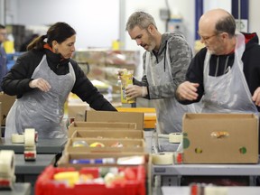 Volunteers sort boxes of food at the Moisson Montréal food bank on Jan. 7, 2019.