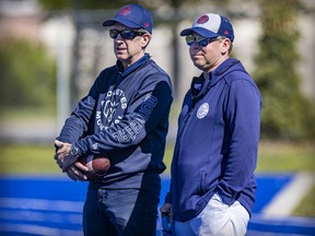 Montreal Alouettes team president Mario Cecchino, left, and general manager Danny Maciocia watch training camp practice in Trois-Rivières on May 25, 2022.