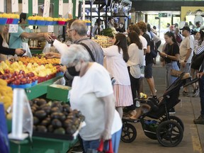 Customers look at produce at the market