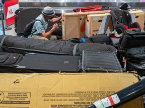 A passenger picks through unclaimed luggage at Trudeau airport on June 29, 2022.