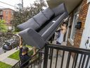 David Giampa, left, and Sean Le Noble fight over a sofa on the stairs as they help friends move into a second-floor apartment in Verdun on Friday.