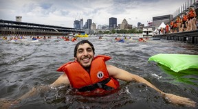 Musician Mike Clay of band Clay and Friends swims off Jacques-Cartier Pier in Montreal’s Old Port on July 1, 2022 as part of the Grand Splash, an annual event calling for better access to the river — and a harbour bath off the Clock Tower Quay, like the one just inaugurated in Quebec City.