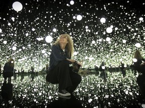 Myriam Achard of the Phi Foundation immerses herself in the Infinity Mirrored Room titled Dancing Lights That Flew Up to the Universe, from the collection of Yayoi Kusama.