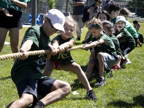 A little girl is all smiles despite her team, Team Italy, being beaten by Team France in the tug of war at the mini-olympics held at Meades Park in Kirkland on Sunday.