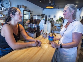 Marie Geller-Oles, left, serves customer Deborah Cope at Victor Rose, the coffee shop she co-owns in Pointe-Claire Village, Thursday, July 7, 2022.