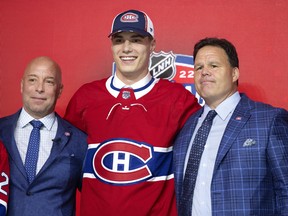 Kent Hughes, left, greets Juraj Slafkovsky with Jeff Gorton as the Montreal Canadiens 1st draft choice during the NHL Draft in Montreal on Thursday, July 7, 2022.