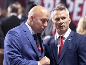 Montreal Canadiens GM Kent Hughes speaks with head coach Martin St. Louis, right, during the NHL draft in Montreal on July 7, 2022.