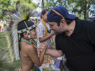Mahgoosh Commonda, from the Kitigan Zibi Algonquin First Nation, is congratulated by his uncle, Yancey Thusky, after being awarded first prize for the boys' grass dancing competition at the 30th edition of the Echoes of a Proud Nation Pow-Wow in Kahnawake on Sunday, July 10, 2022.
