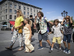 Tourists Chiara Fabricatore and Livio Cirillo walk their children Agata, Luca and Lorenzo through Place Jacques-Cartier on Monday, July 11, 2022.