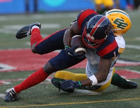 Montreal Alouettes's Hergy Mayala (1) is brought down by Edmonton Elks's Scott Hutter (20) during first-half CFL action in Montreal on Thursday, July 14, 2022.