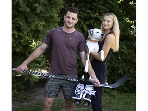 Jeremey Davies and girlfriend Erin Lynch with their dog, Connor. The couple made a hugely successfully TicTok video of Davies signing his NHL contact at a Bureau en Gros photo copy and fax centre.