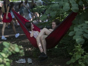 Elisabeth Alexander and Brady Hales of Thunder Bay, Ontario brought their own hammock and found a spot to chill on Day 1 of the Osheaga festival at Parc Jean-Drapeau in Montreal Friday, July 29, 2022.