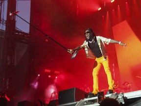 Burna Boy holds up the microphone to the excited crowd on Day 2 of the Osheaga festival at Parc Jean-Drapeau on July 30, 2022.
