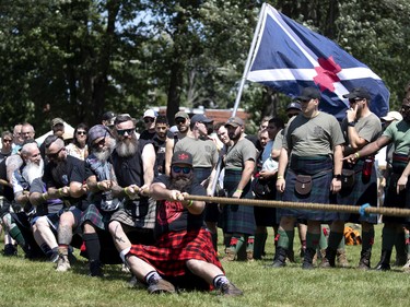 The infantry team from the Black Watch look on as the Bearded Villains lose their round in the tug of war to the Slipped Disk during the Montreal Highland games in Montreal on Sunday, July 31, 2022.