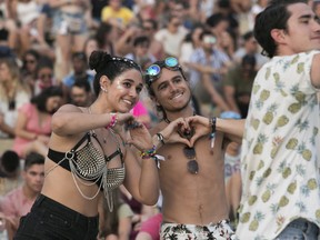 Lydia Shields and Michael Delima make a heart sign on day 2 of the Osheaga Music and Arts Festival at Parc Jean-Drapeau in Montreal Saturday, August 3, 2019.